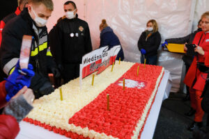Biało- czerwony tort narodowy na scenie, mieszkańcy gminy dookoła tortu
