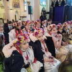 Dzieci w strojach Śląskich oczekujące w ławkach na występ w Kościele