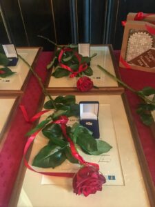 Róża leżąca na stole, otwarte pudełko z odznaczeniem ze srebra